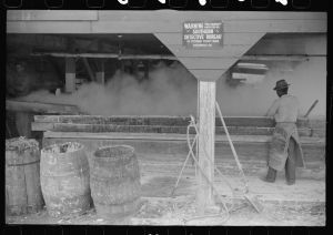 Filtering hot rosin through sieves at a turpentine works in Statesboro, Georgia