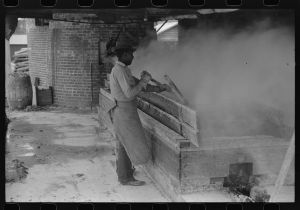 Filtering hot rosin through sieves at a turpentine works in Statesboro, Georgia