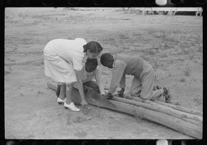 [Untitled photo, possibly related to: Students sawing pieces of bamboo for home economics class to be used in making looms for weaving, Flint River Farms, Georgia]