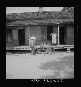 Negro wage laborer and part of his family. He is coming home from the commissary with a week's rations. Macon County, Georgia