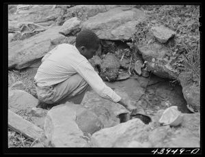 Son of Mr. Frank Cunningham, FSA (Farm Security Administration) borrower, gets some water from the spring, the only source for the family. Near Franklin, Heard County, Georgia