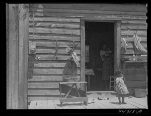 Negro tenant farmer's house showing REA (Rural Electrification Administration) electric meter on wall. Greene County, Georgia