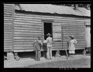 FSA (Farm Security Administration) supervisor measuring windows of Henry Mitchell's home for screens. Greene County, Georgia