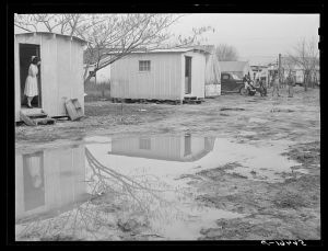 Columbus, Georgia. Metal shelters and tents of Army men and construction workers in backyard of W.T. Mullis, who owns home and property and has grocery store on main highway about three miles from Fort Benning. For the shelters they pay ten dollars a month. For trailer or tent space two dollars a week. Mrs. R.M. Davis, whose husband is a First Sergeant at Fort Benning, now occupying metal shelter, used to live in hallway space in local home nearby and paid twenty dollars a month and had to furnish own bed. Her neighbor said "I hope these real estate men and people in Columbus who are charging so much and stealing from the poor people have to sit in their empty homes and shacks and starve when the defense program is over and finished."