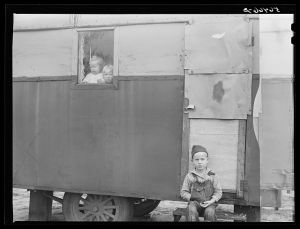 Children looking out of trailer window. Trailer where C.E. Childre and family live in highway about three miles from Fort Benning. He is an auto mechanic and came up to Columbus, Georgia two weeks ago from Albany, Georgia and now works at Columbus Motor Company. They couldn't find any other place to live so had to get a trailer. They pay two dollars a week for space in W.T. Mullis' backyard. Never lived in a trailer before, don't like it, difficult with children and wet weather