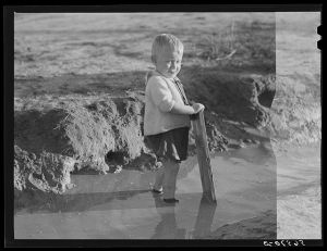 Child playing in front of his home on Milstead Avenue about five miles outside of Columbus, Georgia. Near Fort Benning. His father is at Fort Benning