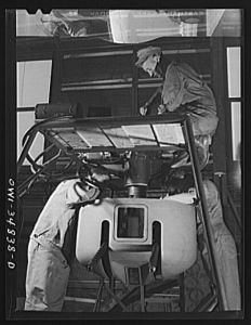 [Untitled photo, possibly related to: Warner Robins, Georgia. Air Service Command, Robins Field. Men of an air depot group studying the mechanism of one of the turrets of a bomber]