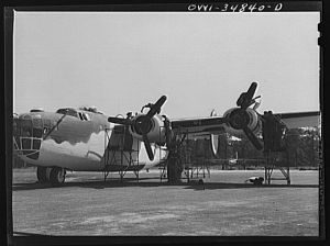 [Untitled photo, possibly related to: Warner Robins, Georgia. Air Service Command, Robins Field. Mechanics removing the cowling of one of the engines of a B-24 bomber]