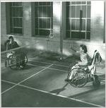Photograph of two wheelchair patients tossing rings over a net to each other in a game of ring volleyball at the Georgia Warm Springs Foundation, Warm Springs, Meriwether County, Georgia, 1941-1951?