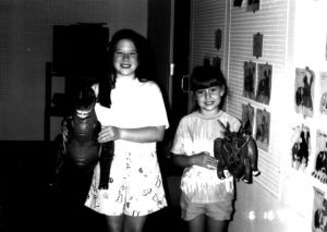 Two unidentified girls holding dinosaurs at the CEA