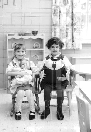 CEA Kindergarten students seated, holding dolls.