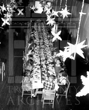CEA Kindergarten students seated at a long table in a decorated room