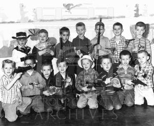 A group of CEA Kindergarten male students with cowboy hats, soldier helmets and toy guns