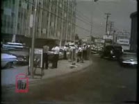 WSB-TV newsfilm clip of a Trailways bus driving through downtown and then parking at a bus station and police arresting two African American female Freedom Riders in Jackson, Mississippi, 1961 May 24