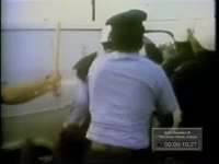 POLICE HOLD MAN WHILE ANOTHER POLICEMAN BEATS HIM ABOUT THE HEAD WITH A CLUB