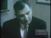 TWO MEN CONFER AT DESK