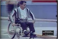HANDICAPPED MAN DEMONSTRATES PROBLEMS OF GETTING AROUND IN A WHEEL- CHAIR