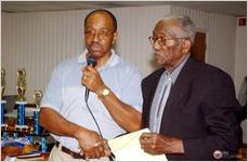 Lowndes County Extension Agent Calvin Willis introduces Robert Church during the 2005 Lowndes County Ham and Egg Show