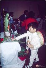 A youngster dressed as Juan Diego presents roses to the Virgen of Guadalupe