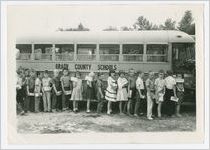 Photograph of schoolchildren lined up next to a school bus, Grady County, Georgia